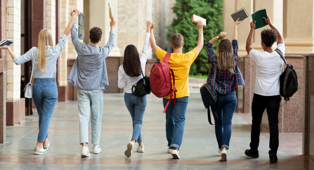 Students with raised hands seen from behind