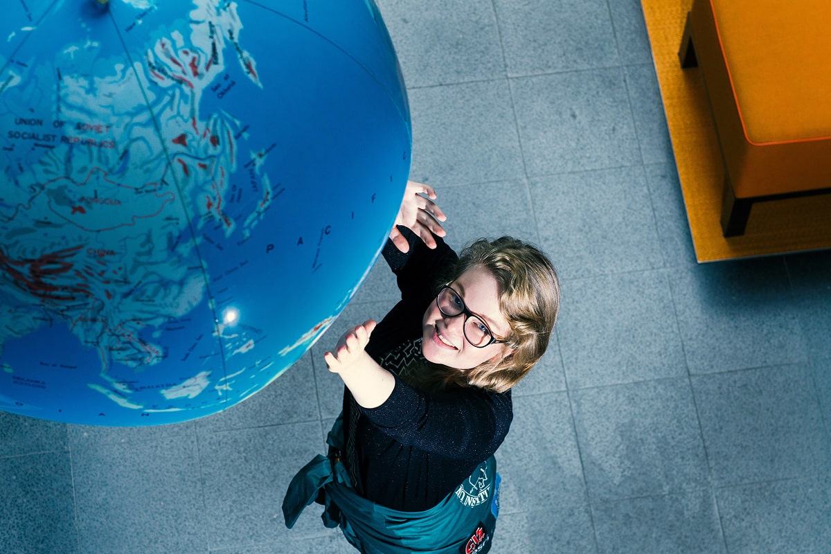 Student reaching for the globe